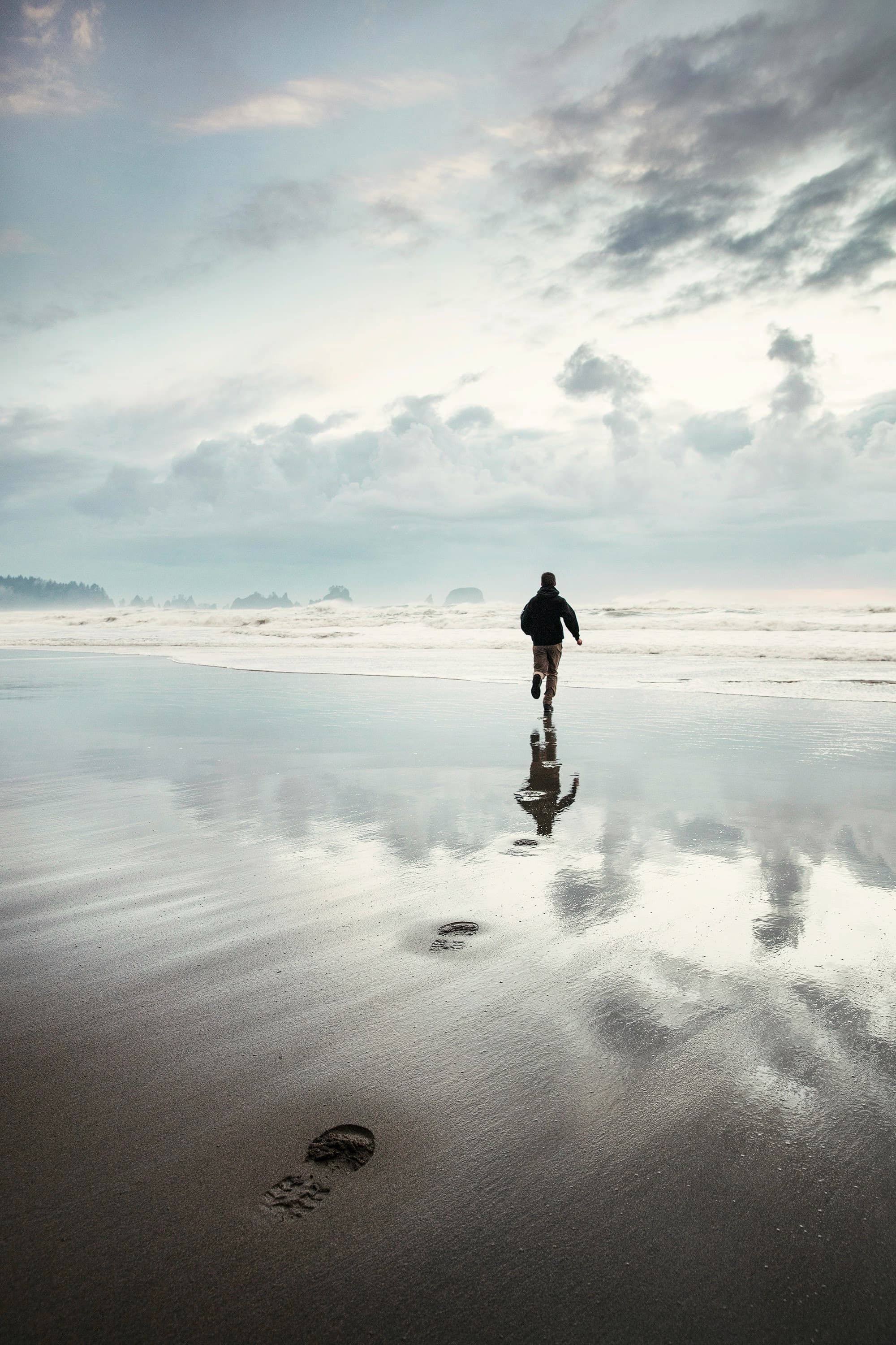 Person running on the beach with tides